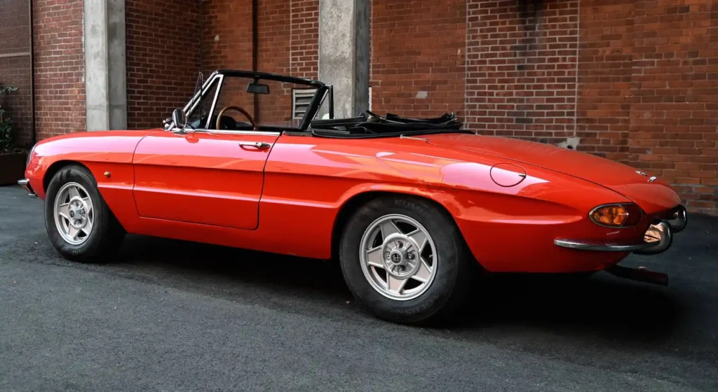 vintage red Alfa Romeo Spider Duetto with its top down